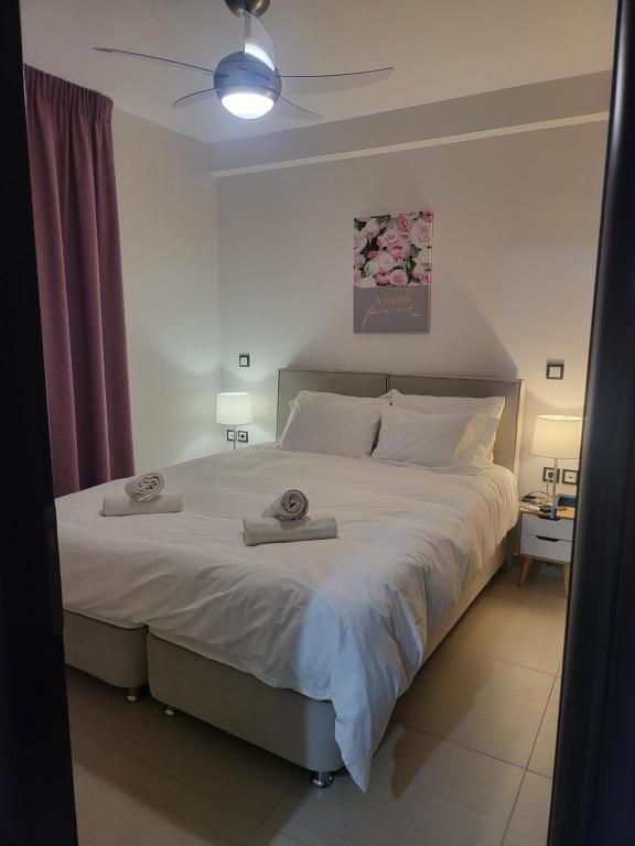 sypialnia z dużym łóżkiem z dwoma ręcznikami w obiekcie Bovis Apartments #1 w mieście Markopoulo Mesogaias