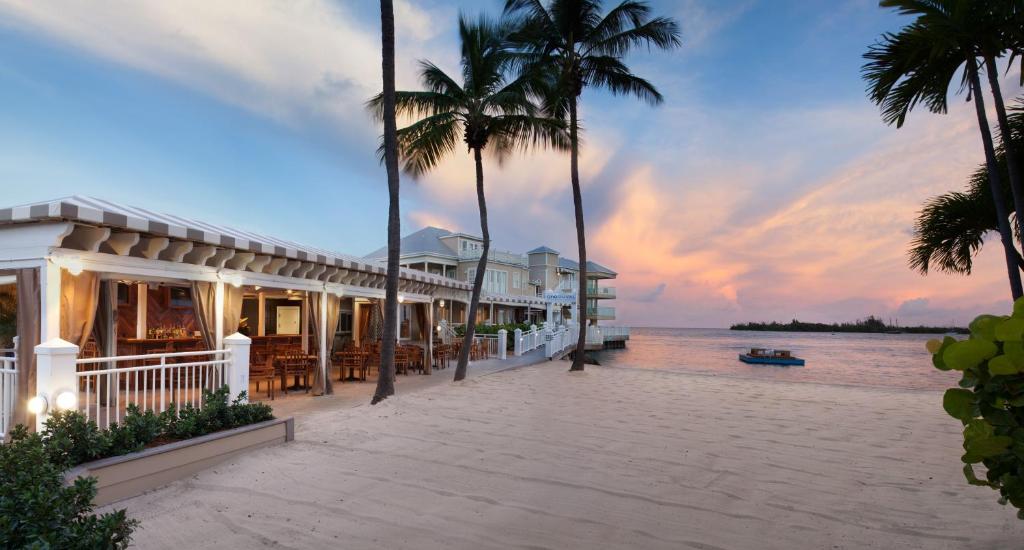 un resort sulla spiaggia al tramonto con palme di Pier House Resort & Spa a Key West