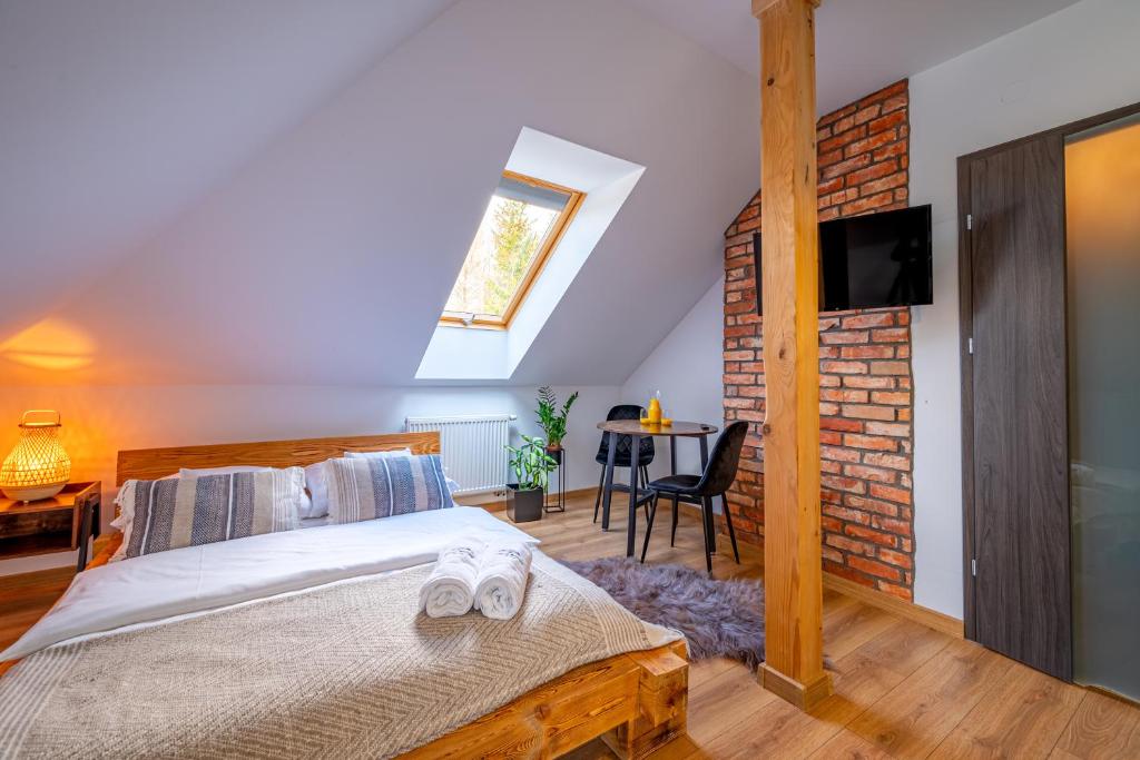 1 dormitorio con cama y pared de ladrillo en Centrum Bieszczad en Lutowiska