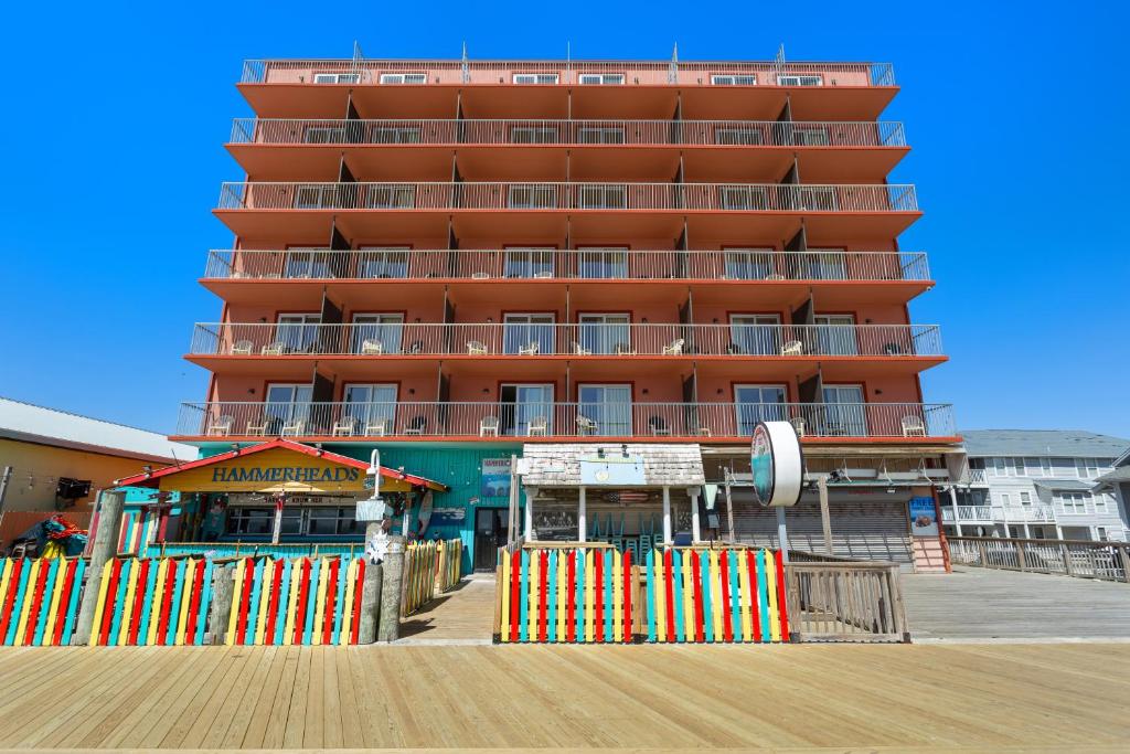 un gran edificio rojo en un muelle junto a un paseo marítimo en Americana Hotel Boardwalk en Ocean City