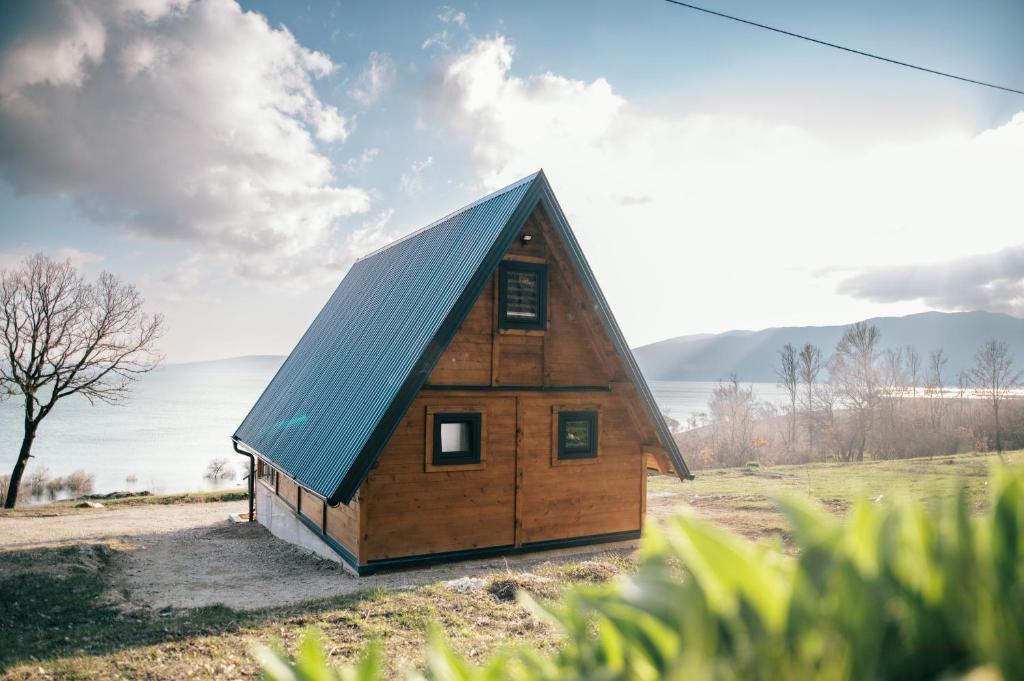 Cabaña de madera pequeña con techo azul en Lake House Beliz, en Livno