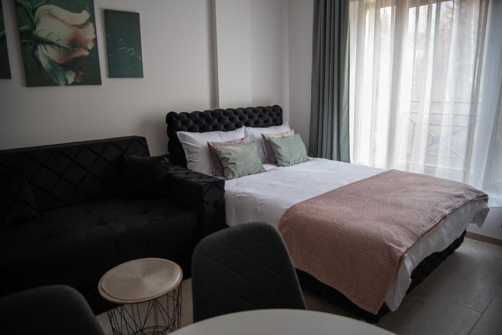 ein Schlafzimmer mit einem großen Bett und einer Couch in der Unterkunft Milmari Nlux 74 in Kopaonik
