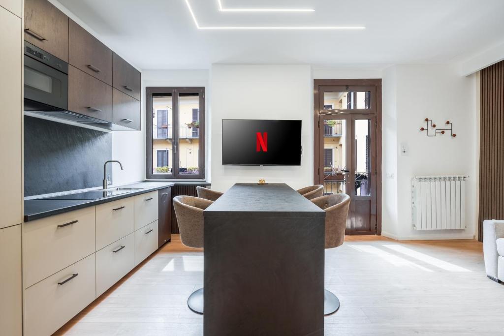uma cozinha com uma grande ilha com uma televisão em Bilocale Moderno - City Center em Milão