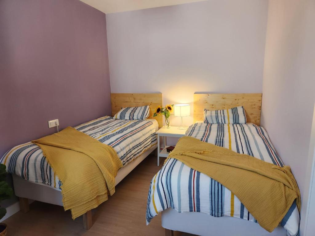 um quarto com 2 camas e uma mesa com um candeeiro em Apartamento Moderno en León ciudad em León