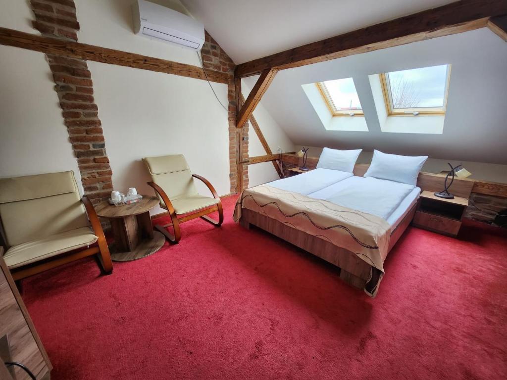 a bedroom with a bed and a table and a chair at Antique ApartHotel in Alba Iulia