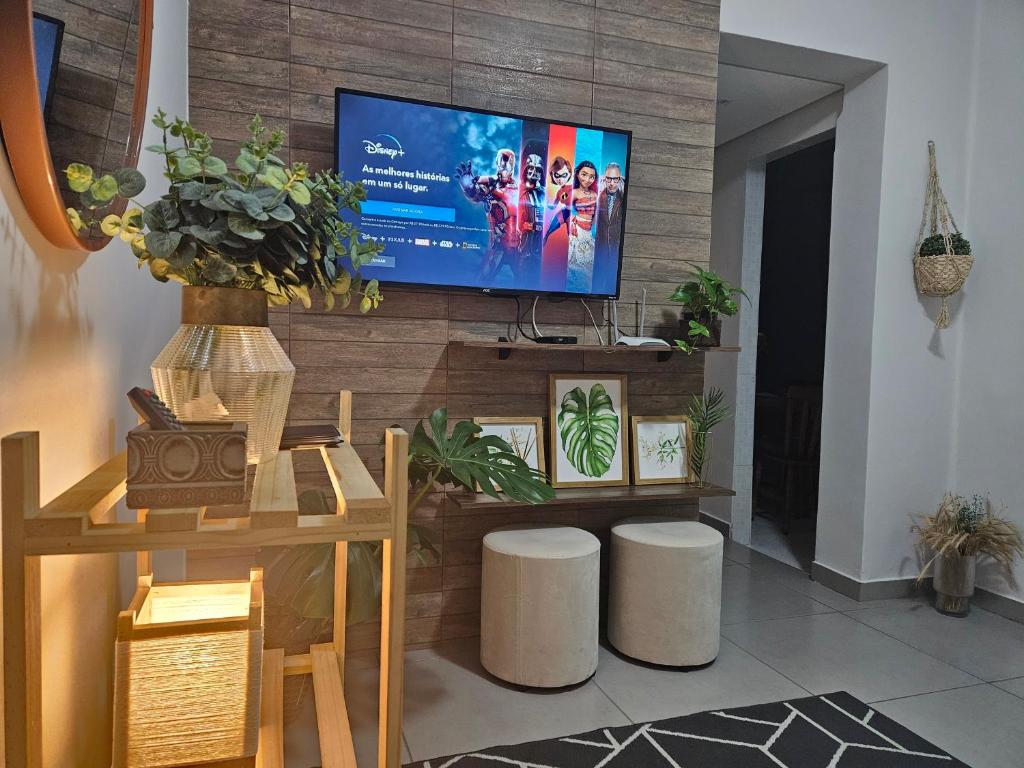 a living room with a flat screen tv on a wall at CASA_ESTRELA in Angra dos Reis