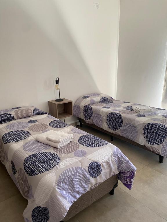- deux lits assis l'un à côté de l'autre dans une pièce dans l'établissement Departamento Amoblado MorenoPark 683, à Luján de Cuyo