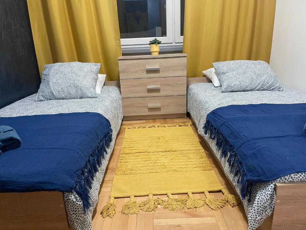 a bedroom with two beds and a dresser with a window at Pokoje do wynajęcia - Podwisłocze 8a in Rzeszów