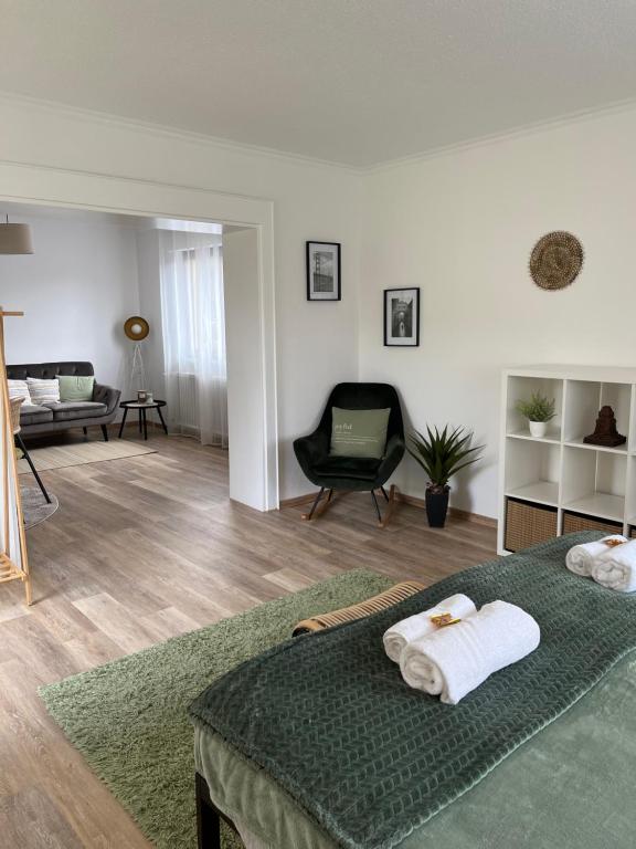 ein Schlafzimmer mit einem Bett und ein Wohnzimmer in der Unterkunft Korbstadt-Villa Rattan-Design mit Balkon, Garten, Arbeitsplatz, Küche in Lichtenfels