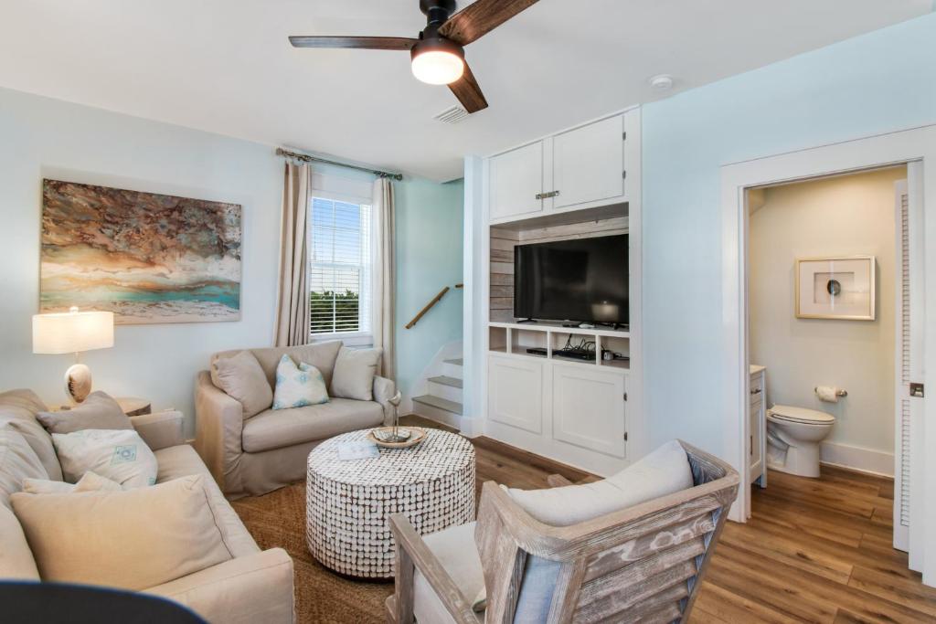 a living room with a couch and a tv at Bungalows at Seagrove 135 - MerSea in Seagrove Beach