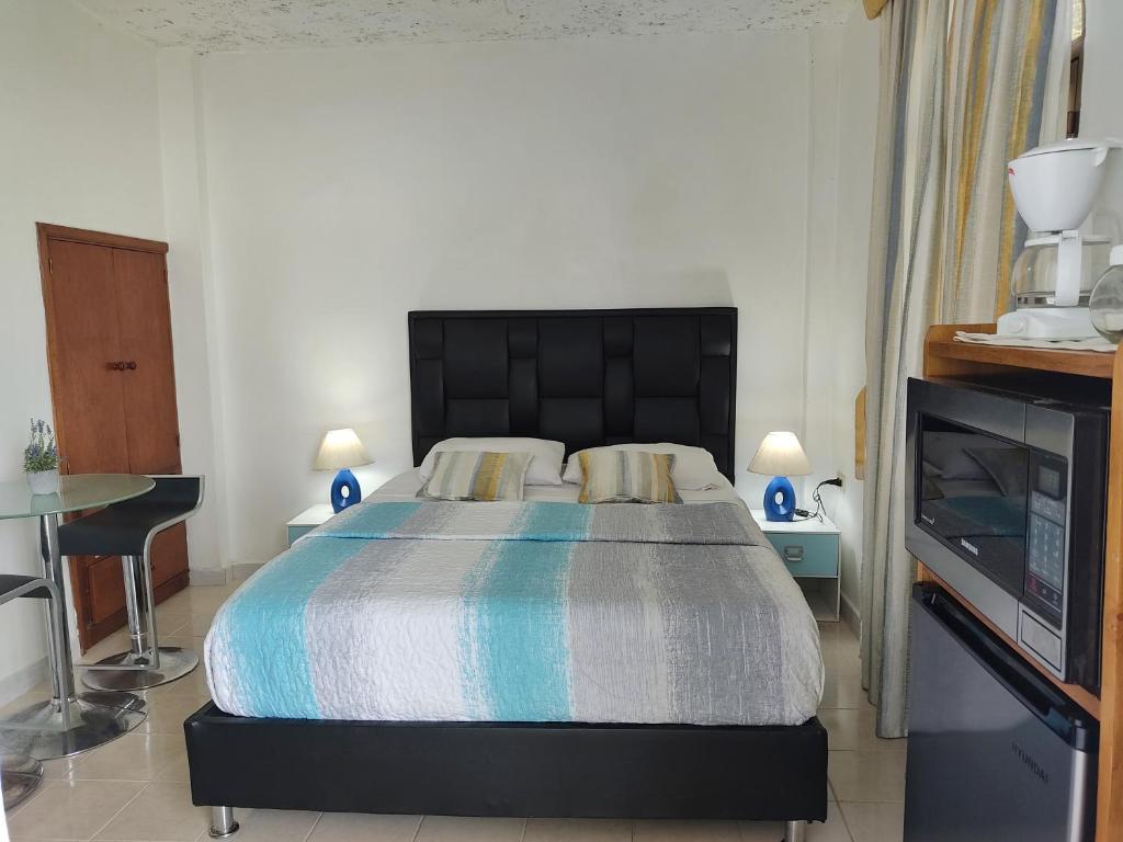 1 dormitorio con 1 cama grande y 1 mesa en BELLA SUITE frente al Aeropuerto, en Catia La Mar