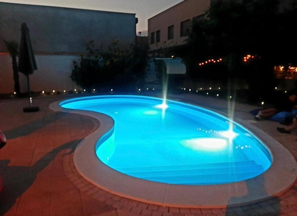 una piscina in un cortile di notte di Infinity a Novi Sad