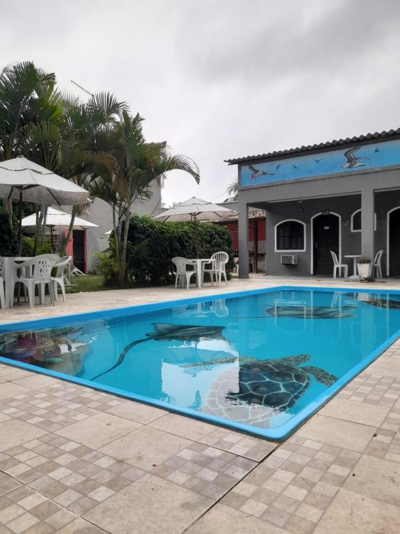 una piscina de agua azul en un complejo en Pousada Flora Búzios, en Búzios