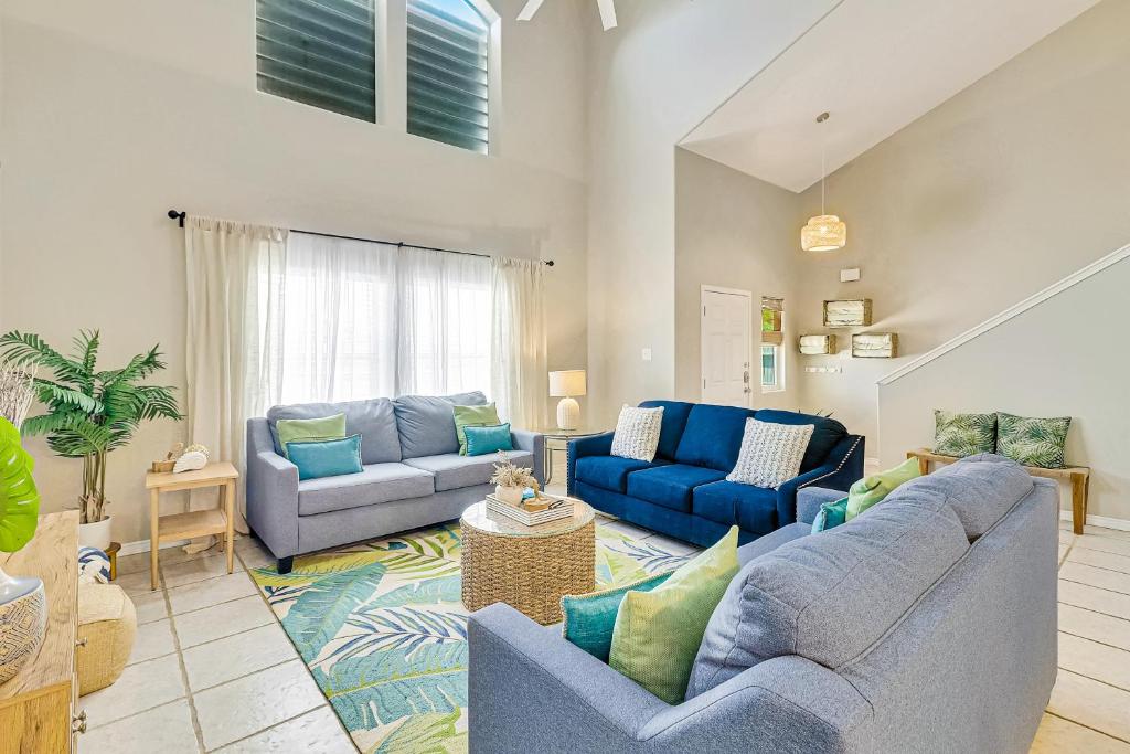 a living room with two blue couches at Palm Tree Paradise in Padre Island