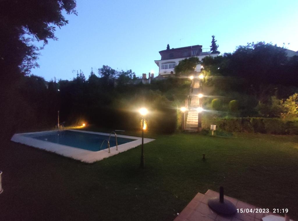 uma piscina num quintal com uma casa ao fundo em Los Cipreses em Córdoba