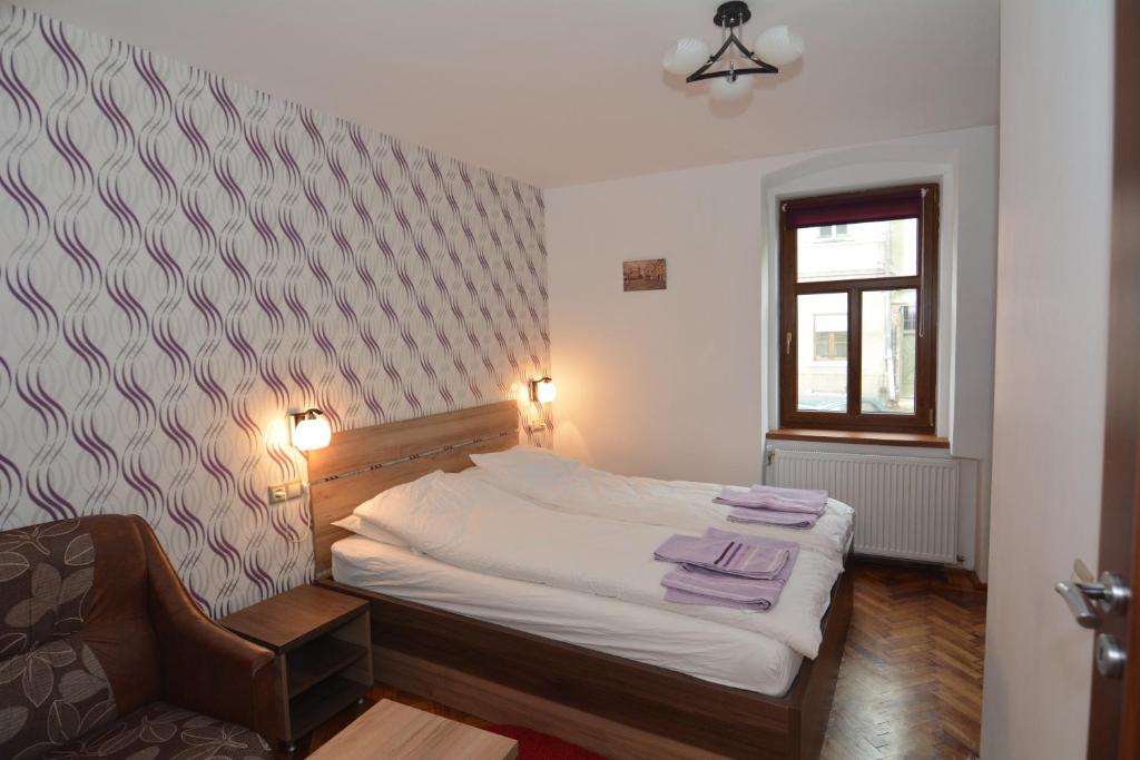 una camera da letto con un letto e asciugamani viola di Apartament Supercentral Sibiu a Sibiu