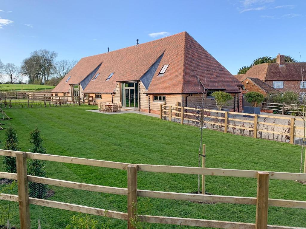 a house with a fence in front of a field at Hatchers Barn - Uk42080 in East Garston