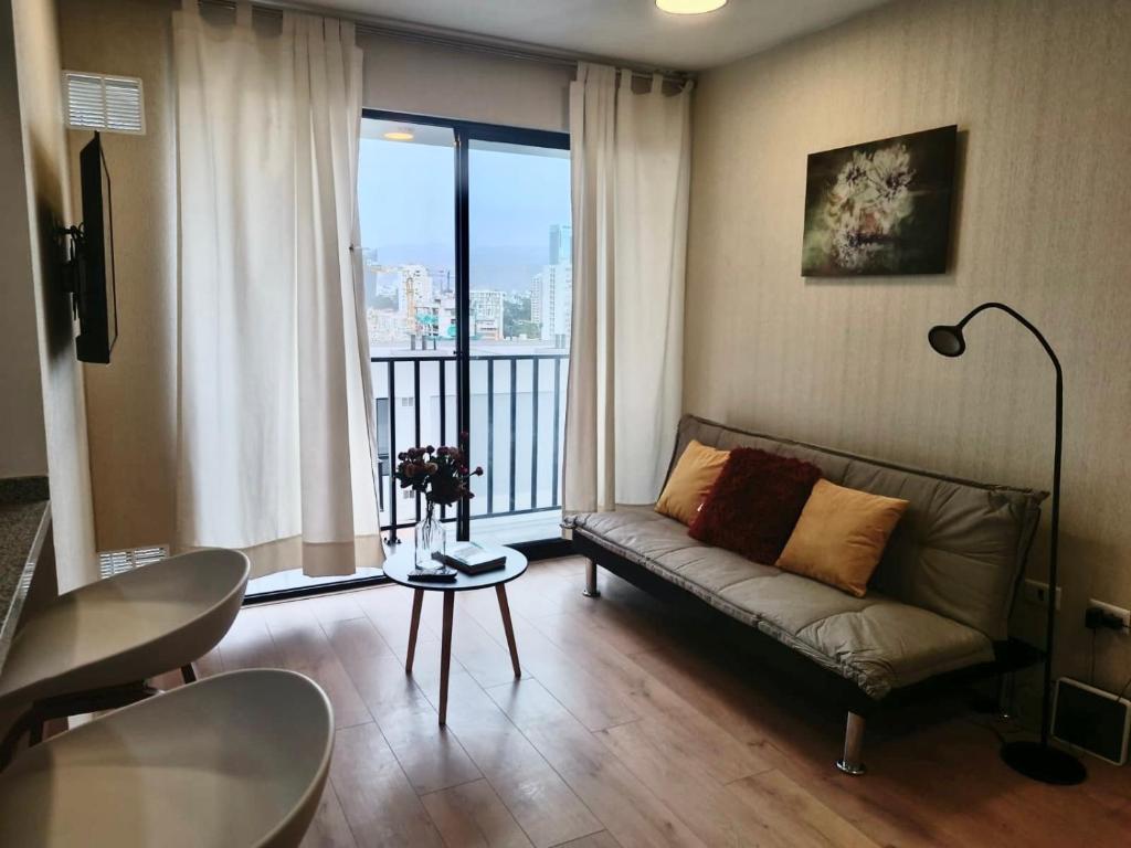 sala de estar con sofá y ventana grande en Massimo Apartament en Lima