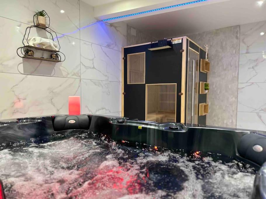 - une baignoire remplie d'eau dans la chambre dans l'établissement Villa Spacieuse SPA Sauna Billiard Netflix, à Strasbourg