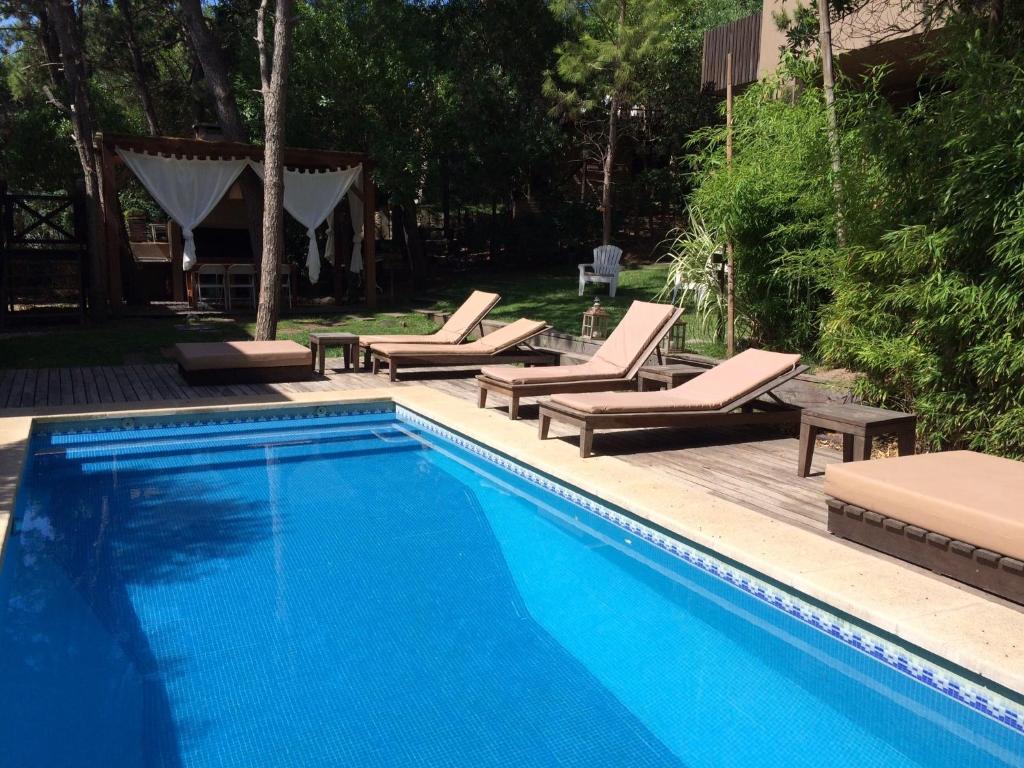 a swimming pool with chaise lounge chairs and a swimming pool at Plenilunio Mar de las Pampas in Mar de las Pampas