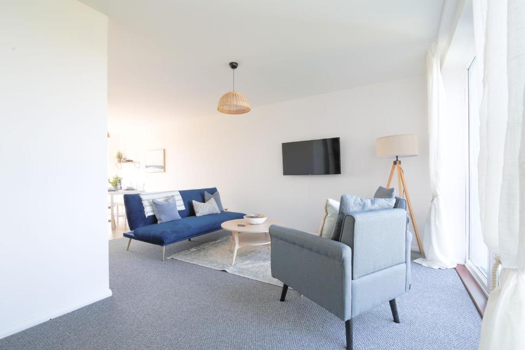 a living room with two blue chairs and a tv at StayRight 2Bed Apartment Overlooking Water with Free parking and 2 Bathrooms in Cardiff