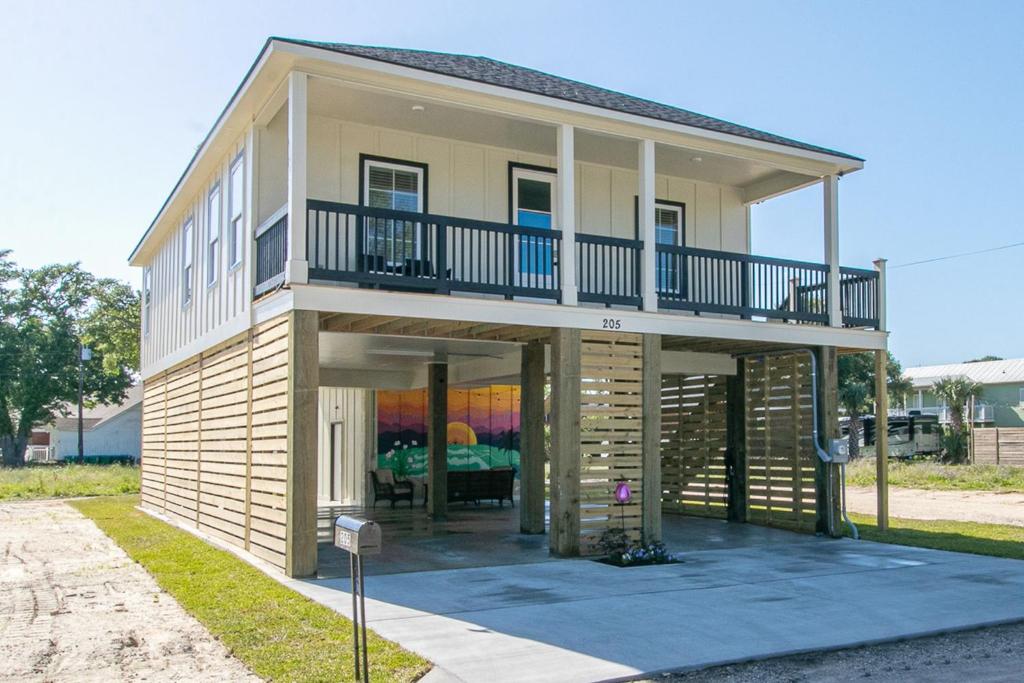 a large house with a balcony on top of it at Luxury Family home near Casinos with King Bed, steps away from the Beach, Game Room, and Free Parking in Gulfport