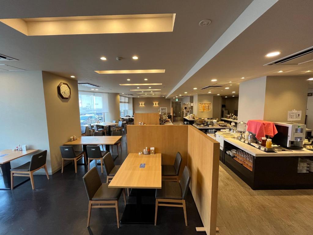 un restaurant avec des tables, des chaises et un comptoir dans l'établissement Monbetsu Prince Hotel, à Mombetsu