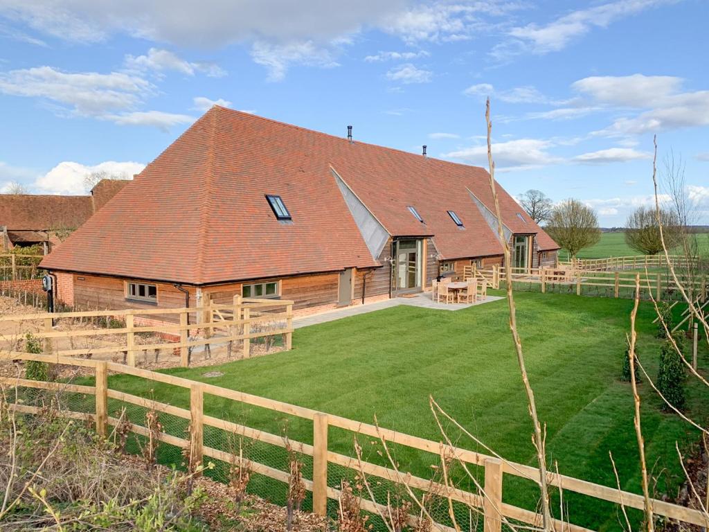 a large wooden barn with a green yard at Olivers Barn - Uk42081 in East Garston