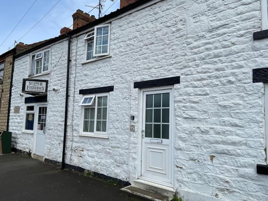 a white brick building with a white door and windows at Fryers Cottage, Seamer, 3 Bed cottage sleeps 5 people in Seamer