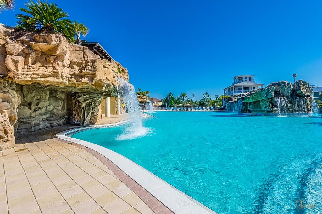 a swimming pool with a waterfall in a resort at Resort-Style Pool! - Minutes to Beach! - FLSRB2 in Santa Rosa Beach