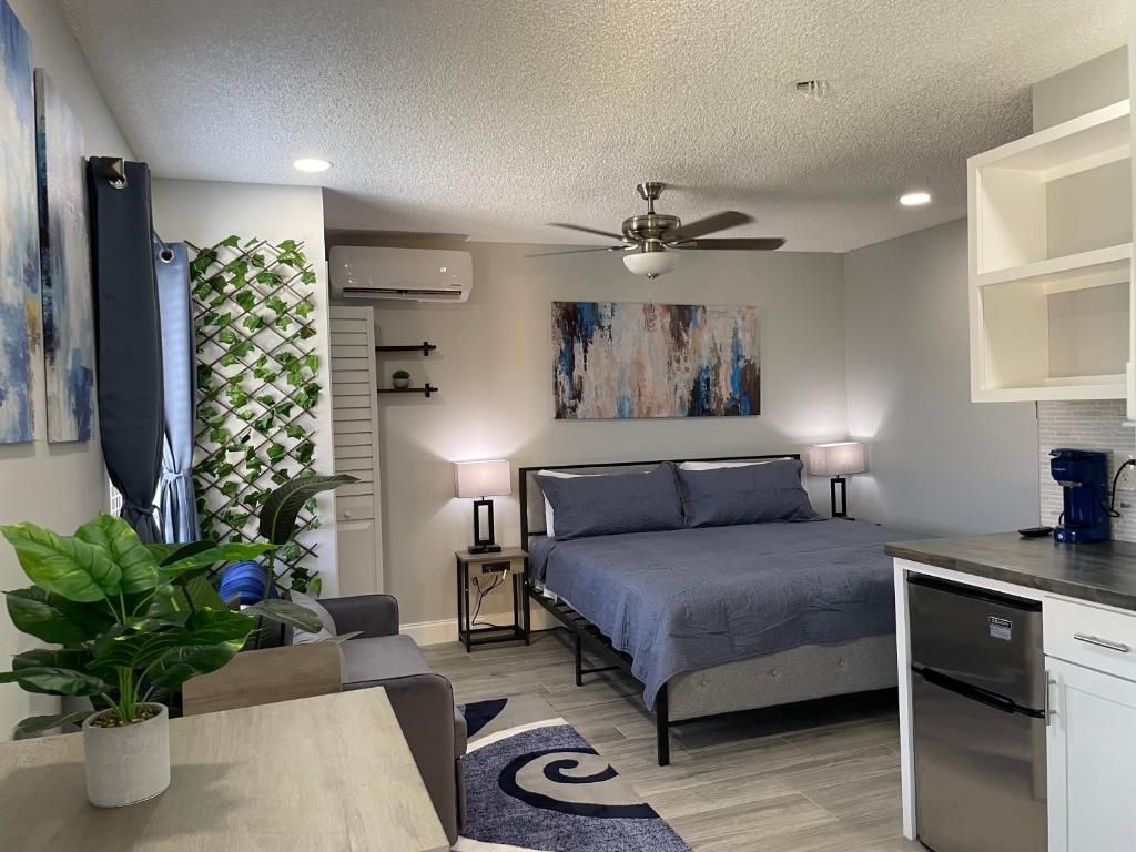 a bedroom with a bed and a kitchen at Sunny Palms Inn in Lake Worth