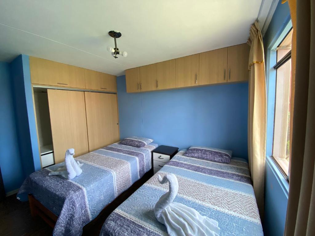 um quarto com três camas com cisnes em Apart La Posada em Tacna