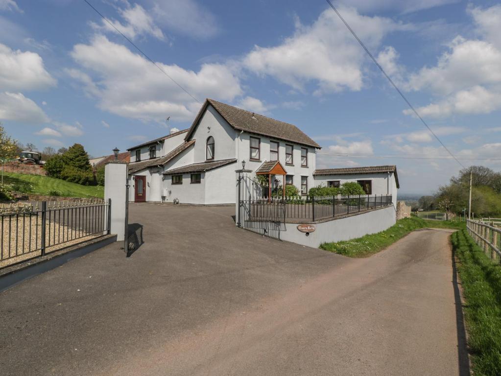 a white house with a fence and a driveway at Moors Farm in Cinderford