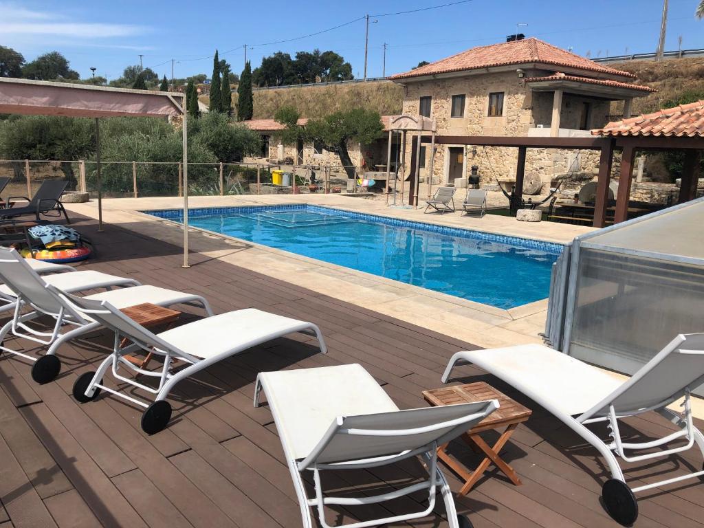 una terraza con sillas y una piscina en Quinta das Pias - Holiday Farm, en Pinhel