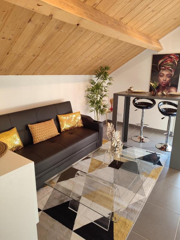 sala de estar con sofá negro y mesa en La maison blanche en Limoges