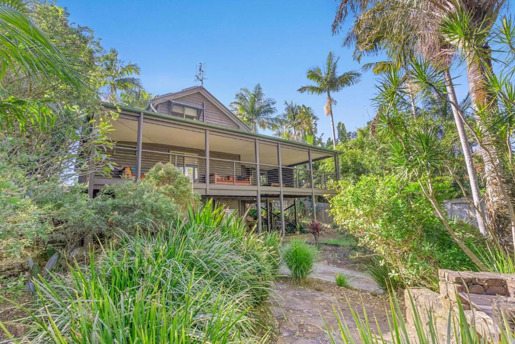 an exterior view of a house with palm trees at Fuller Holidays - Leah's Retreat - Relax in nature in Bangalow