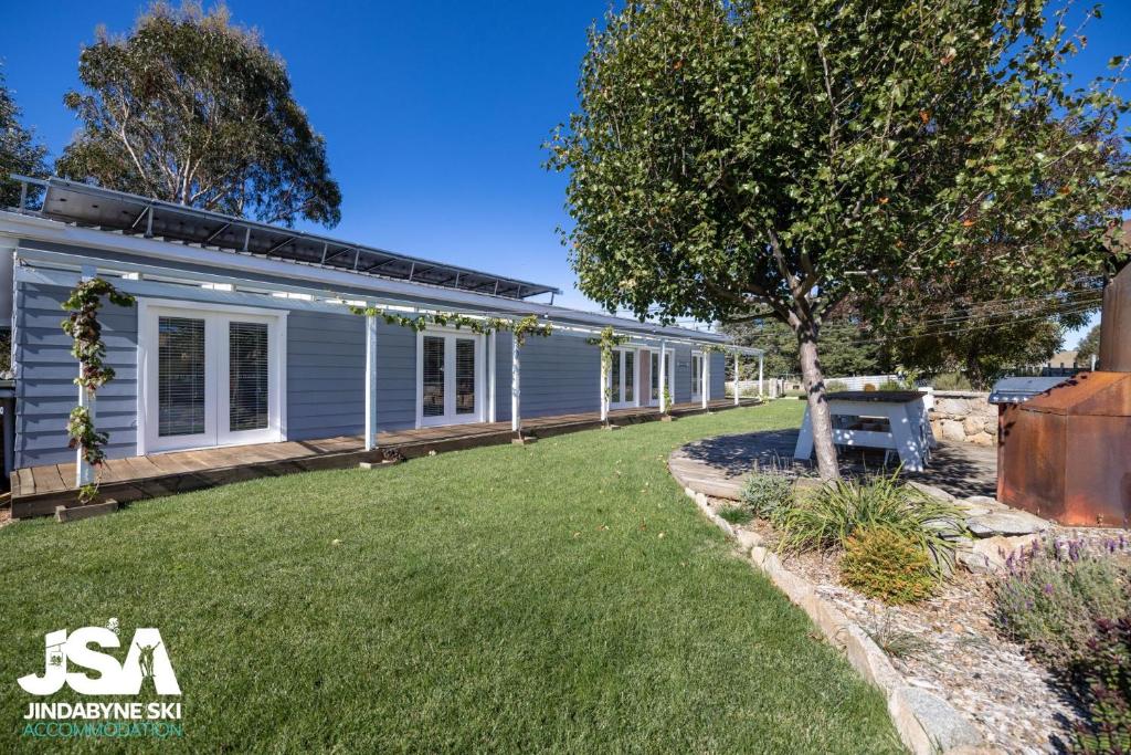 una casa con un patio al lado de un edificio en Edelweiss Cottage en Berridale