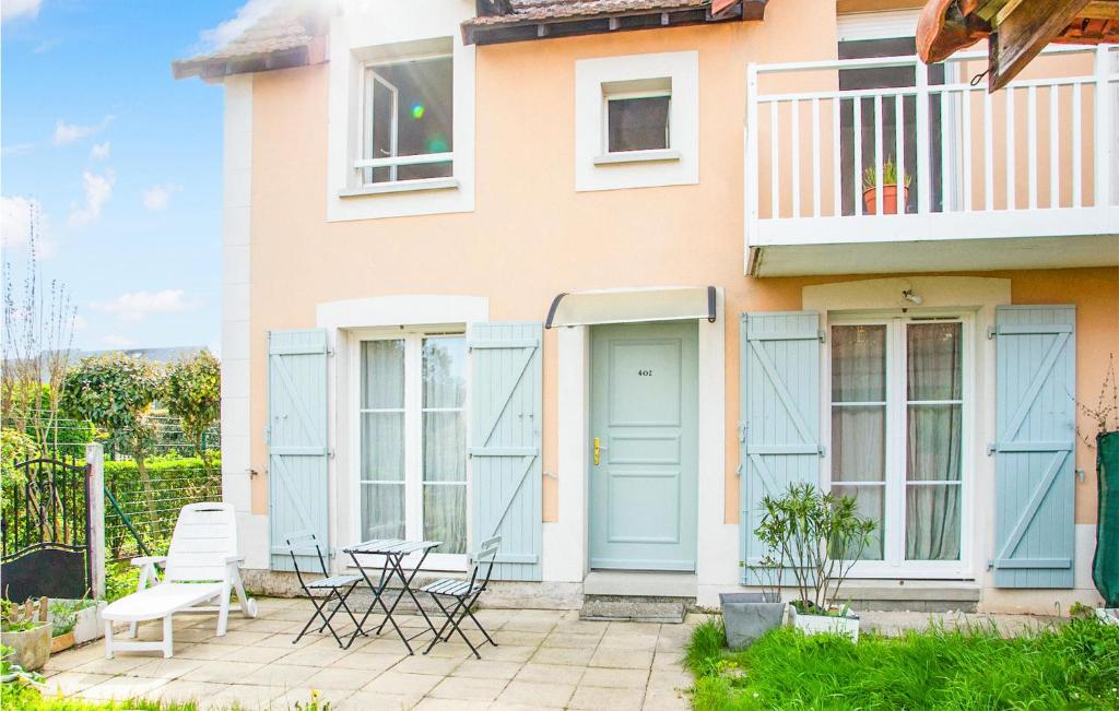 ディーブ・シュル・メールにあるStunning Home In Dives-sur-mer With Outdoor Swimming Poolの青いドアと椅子が備わるパティオ付きの家