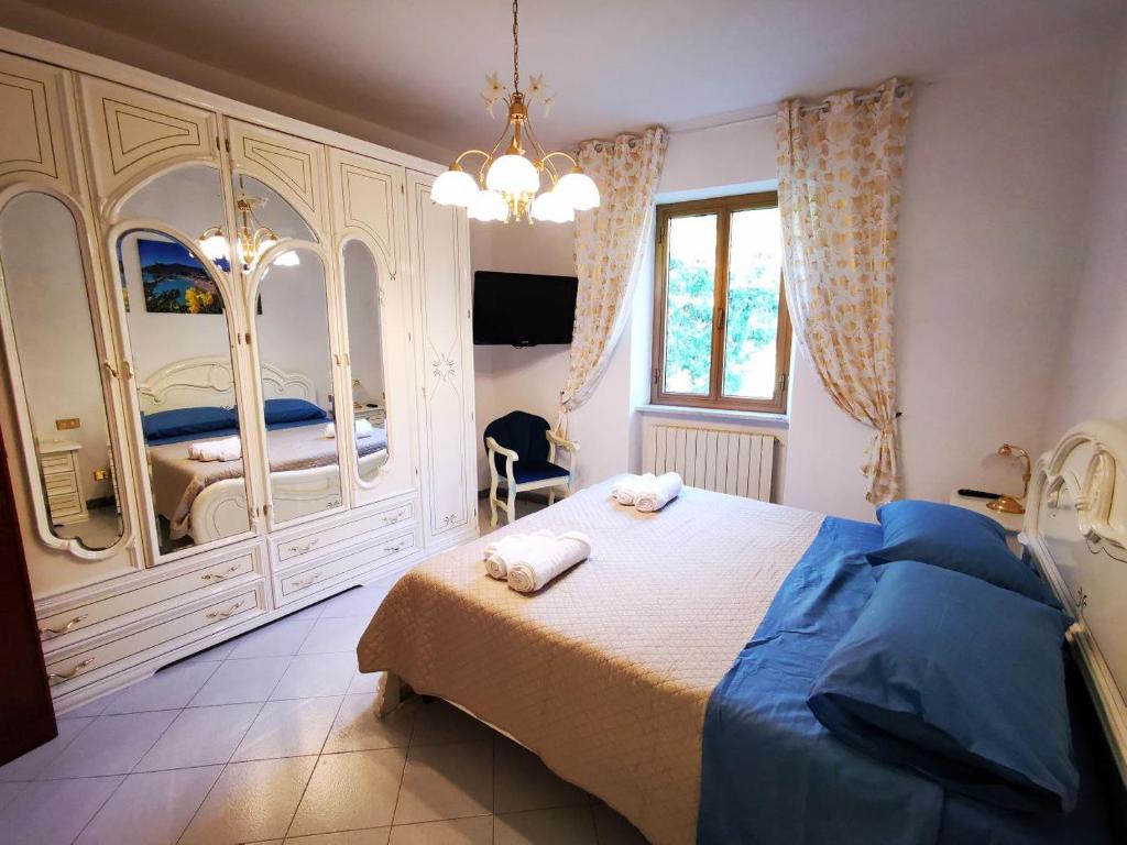 a bedroom with a large bed and a chandelier at La Casa di Lice in Moneglia
