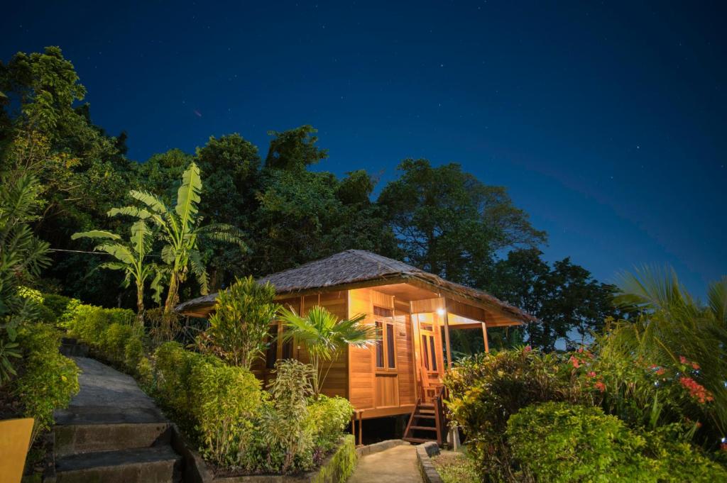 uma cabana no meio de um jardim à noite em K2 Lembeh Dive Resort em Bitung