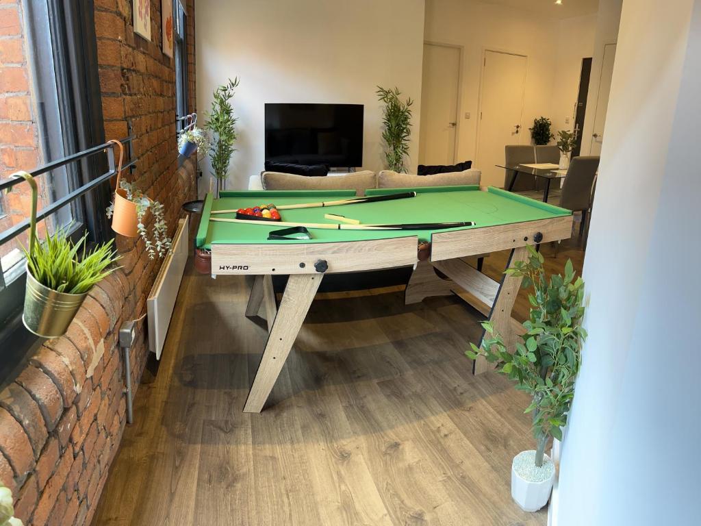 a ping pong table in a living room at Luxury one bed apartment in Manchester city center in Manchester