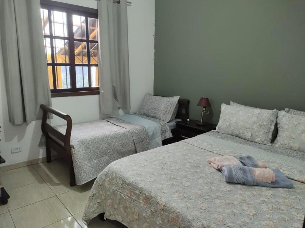 1 Schlafzimmer mit 2 Betten und einem Fenster in der Unterkunft Casa cantinho do aconchego in Campos do Jordão