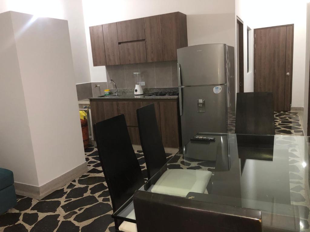 a kitchen with a glass table and a refrigerator at Apartamento amplio, excelente ubicación 3 alcobas 403 in Medellín