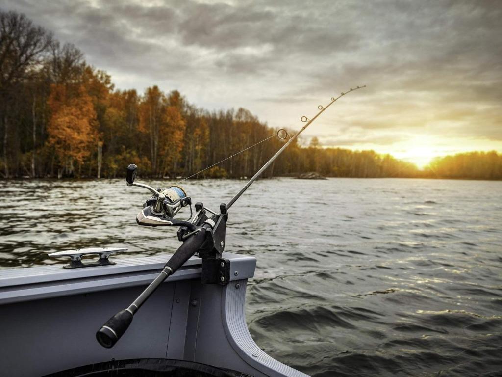 uma pessoa num barco com uma cana de pesca na água em Holiday home VETLANDA em Vetlanda