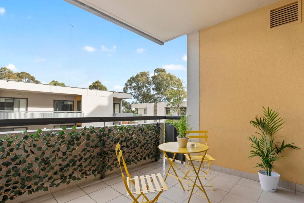 een patio met een tafel en stoelen op een balkon bij A Comfy & Cozy 2BR Apt Near Flemington Races in Melbourne