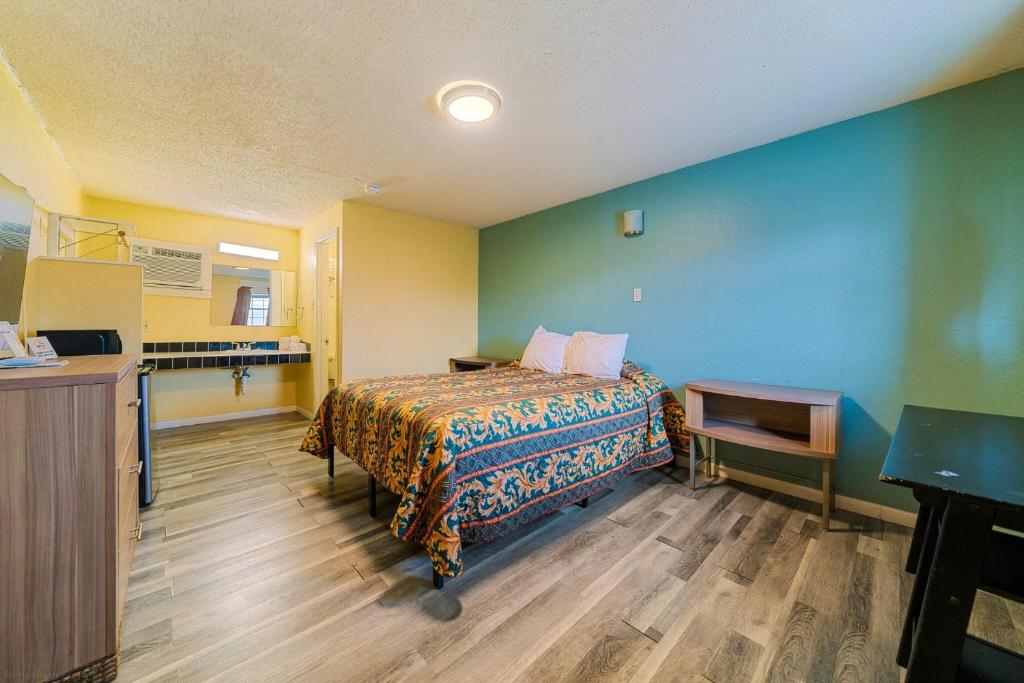 a hotel room with a bed and a desk at Catalina Motel in Corpus Christi