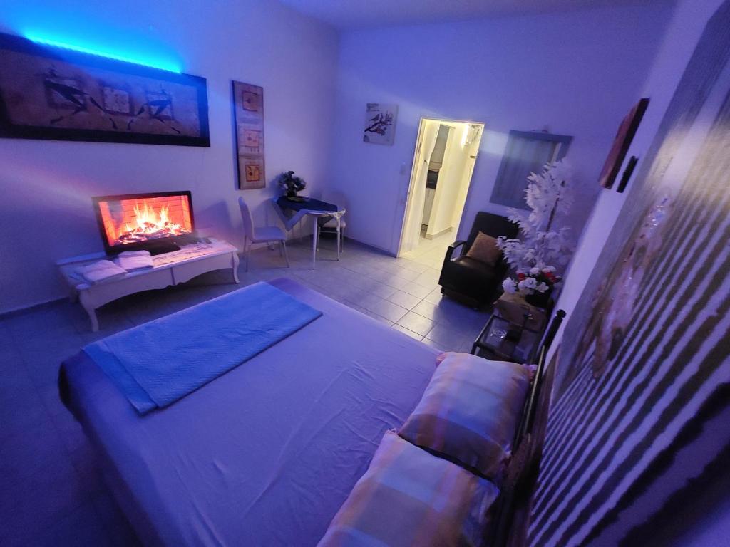 a bedroom with a bed and a living room with a fireplace at Modern Studio Central Haifa Free WiFi דירת נופש מאובזרת בחיפה in Haifa