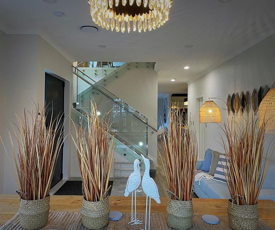 a living room with two swans statues and a staircase at Flat Bush Holiday Accomodation in Auckland