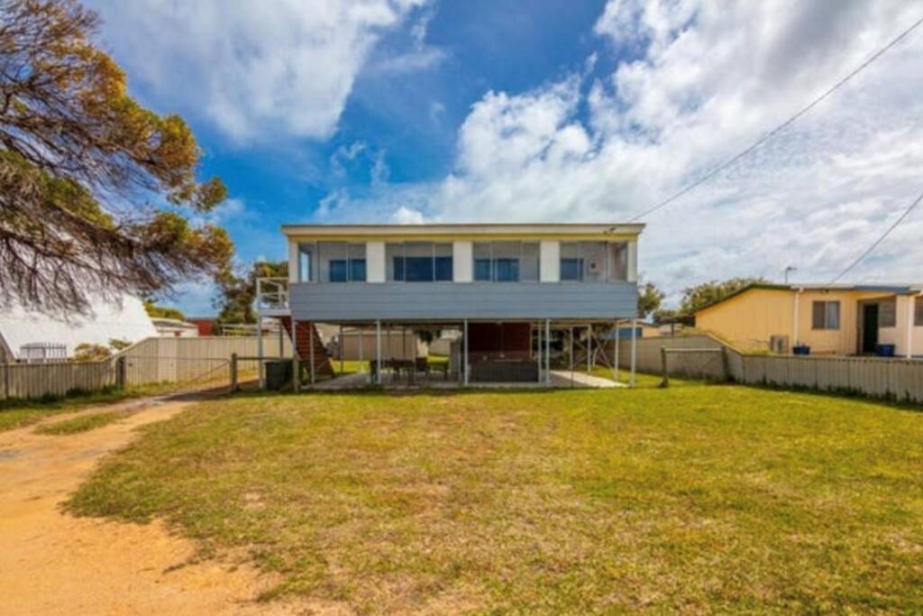 una casa blanca con una valla y un patio en Cervantes Beach Shack, en Cervantes