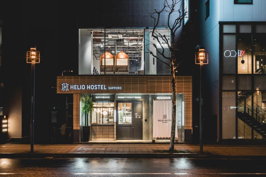 HELIO HOSTEL SAPPORO في سابورو: متجر أمام مبنى في الليل
